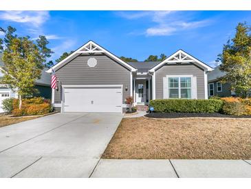 Charming single-story home with gray siding, white trim, well-manicured landscaping, and an attached garage at 112 Riviera Dr, Summerville, SC 29483