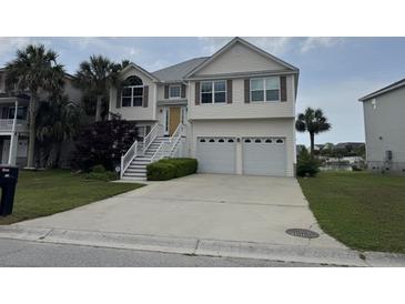 Inviting two-story home with a two-car garage, palm trees, and a well-maintained lawn and garden at 1144 Clearspring Dr, Charleston, SC 29412