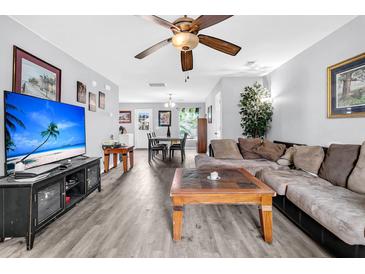 Inviting living room featuring hardwood floors, ceiling fan, a comfortable sofa, and a modern entertainment center at 1516 Mandarin Ct, Summerville, SC 29483