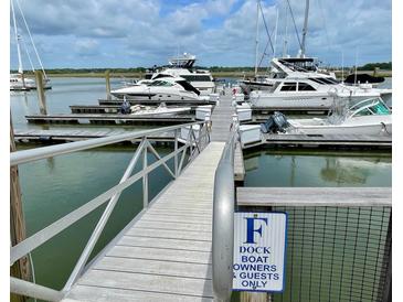 View of the boat dock with several yachts under a cloudy blue sky at 1880 Andell Bluff Blvd # F-3, Seabrook Island, SC 29455