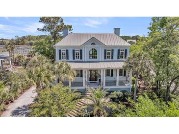 Stately two-story home with a metal roof, inviting front porch, and lush landscaping at 2254 Beckenham Dr, Mount Pleasant, SC 29466
