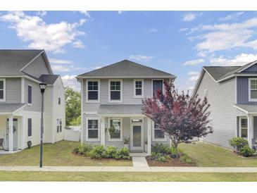 Charming two-story home boasts curb appeal with its well-maintained yard and inviting entrance at 3990 Hillyard St, North Charleston, SC 29405