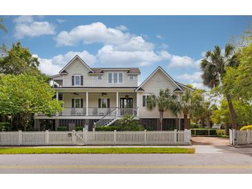 Stunning two-story home with a porch, black shutters, and a white picket fence for curb appeal at 407 Pitt St, Mount Pleasant, SC 29464