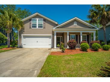 Charming single-Gathering home featuring a two-car garage, covered porch, and beautifully landscaped front yard at 5008 Bowles Dr, Summerville, SC 29485