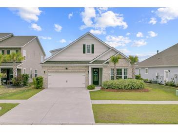 Charming home featuring a brick facade, attached garage, palm trees, and a well-manicured front yard at 523 Fern Tree Dr, Summerville, SC 29486