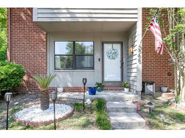 Inviting front porch with red brick and landscaped garden, complete with an American flag at 565 Travelers Blvd, Summerville, SC 29485