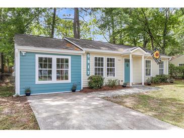 Charming single-story home with a delightful blue accent and a well-manicured front yard at 5817 Canterbury Dr, Hanahan, SC 29410