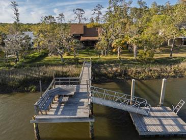 Picturesque waterfront home featuring a private dock, boat lift, and scenic views at 7897 Russell Creek Dr, Edisto Island, SC 29438