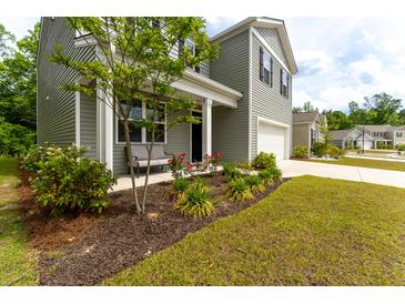 Inviting two-story home featuring a charming front porch and well-maintained landscaping at 131 Cloverleaf St, Summerville, SC 29483
