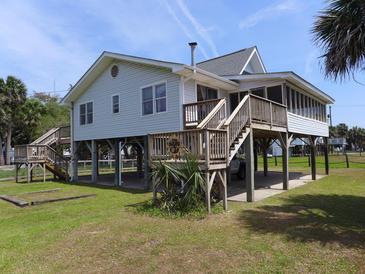 Charming raised beach house with wooden stairs and screened in porch at 1603 Lybrand St, Edisto Island, SC 29438