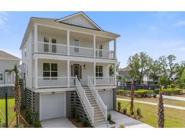 Stunning elevated two-story home featuring double porches, a two-car garage, and a beautifully landscaped yard at 1619 Cultivation Ln, Mount Pleasant, SC 29466