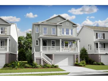 Charming two-story home featuring a garage and inviting front porch with white railing and a well-manicured lawn at 1664 Siloh St # 471, Mount Pleasant, SC 29466