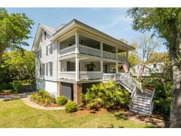 Charming home featuring a double porch, lush landscaping, and an inviting staircase at 2802 Ion Ave, Sullivans Island, SC 29482