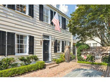 Charming home exterior featuring classic architecture and an American flag at 32 Church St, Charleston, SC 29401