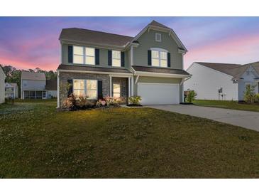 Charming two-story home features a manicured lawn, brick accents, and a two-car garage at 433 Thoroughbred Dr, Moncks Corner, SC 29461