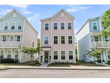 Charming three-story home with a pastel pink exterior and manicured front yard, flanked by similar homes at 4429 Avery Ave, North Charleston, SC 29405