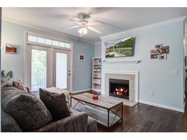 Inviting living room featuring a cozy fireplace, ceiling fan, and access to the outdoor balcony at 45 Sycamore Ave # 1532, Charleston, SC 29407