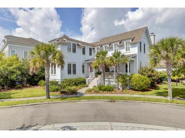 Inviting two-story home with white siding, a front porch, palm trees, and lush landscaping, offering classic curb appeal at 509 Gilberts Lndg, Mount Pleasant, SC 29464