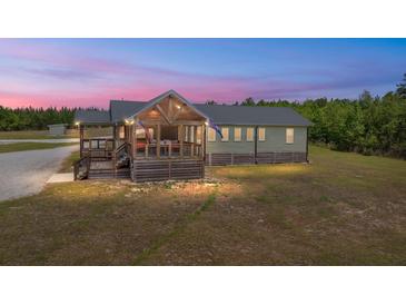 Charming home featuring a screened-in porch and views of the landscaped yard at 5653 Wire Rd, Branchville, SC 29432