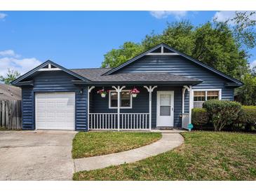 Charming blue home with a white porch, green lawn, and attached garage at 8268 Timberidge Ct, North Charleston, SC 29420