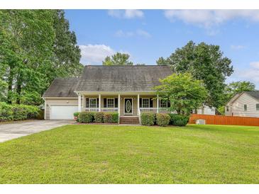 Charming single-story home featuring a welcoming front porch, lush lawn, and attached garage at 102 Bristol Ln, Goose Creek, SC 29445