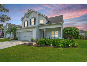 Charming two-story home featuring a manicured lawn, tidy landscaping, and an attached two-car garage at 107 Tandil Ct, Summerville, SC 29483