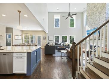 Open-concept living room features a fireplace, lots of natural light, and an elegant staircase at 1166 Turkey Trot Dr, Johns Island, SC 29455