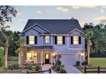 Charming two-story home with palm trees and a well-manicured lawn on a sunny day at 121 Royal Cainhoy Way, Huger, SC 29450