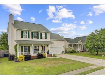 Charming two-story home with a well-manicured lawn and inviting front porch perfect for relaxing at 137 Cotillion Cres, Summerville, SC 29483