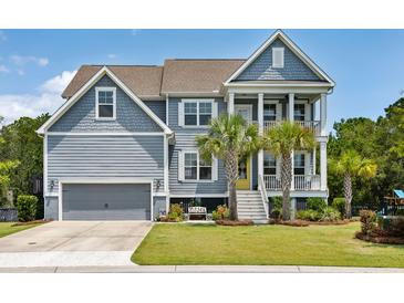 Charming two-story home with a garage, palm trees, a yellow front door, and a cozy bench in the front yard at 1644 Fort Palmetto Cir, Mount Pleasant, SC 29466