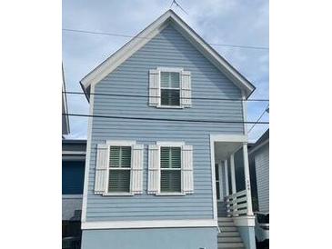 Charming blue two-story home with white trim, shuttered windows, and a welcoming front porch at 169 Jackson St, Charleston, SC 29403