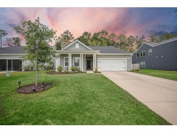 Charming home with a well-manicured lawn, inviting porch, and attached two-car garage at 221 Lucca Dr, Summerville, SC 29486