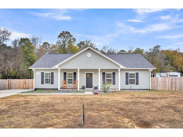 Charming single-story home with a welcoming front porch and rocking chairs at 255 S Railroad Ave, Ridgeville, SC 29472
