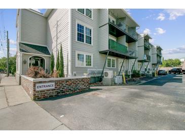 Apartment building with gray siding, black iron balconies and parking lot at 259 E Bay St # 7C, Charleston, SC 29401