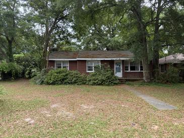 Charming single-story brick home with a welcoming front yard, surrounded by mature trees and established landscaping at 609 Coral St, Mount Pleasant, SC 29464