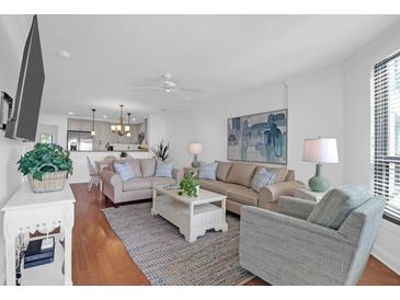 Bright living room featuring hardwood floors, comfortable seating, and an open layout connecting to the kitchen at 8000 Palmetto Dr # 104-A, Isle of Palms, SC 29451