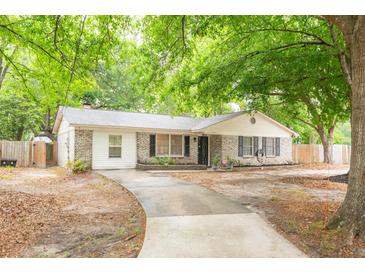 Charming brick home featuring a well-maintained lawn and a long driveway leading to the entrance at 9887 Midview Dr, Ladson, SC 29456