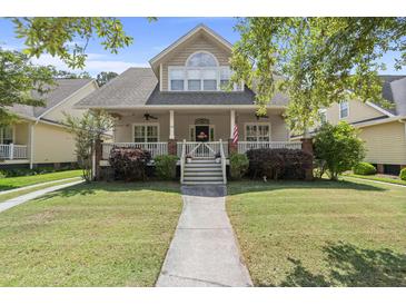 Charming two-story home featuring a welcoming front porch with white railings and a well-maintained lawn at 115 S Ainsdale Dr, Charleston, SC 29414