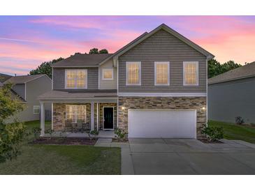 Charming two-story home featuring stone accents, a covered porch, and a two-car garage at 118 Beacon Falls Ct, Summerville, SC 29486