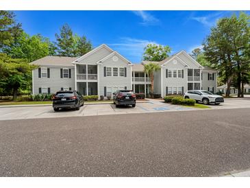 Two-story condo complex showcasing neutral siding, black shutters, and well-manicured landscaping at 1606 Whitby Ln, Charleston, SC 29414