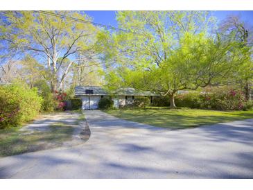 Charming single-story home with a well-manicured front yard, long driveway, and mature shade trees at 2138 Clayton St, Charleston, SC 29414