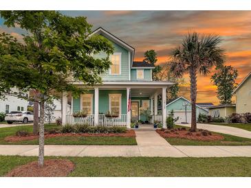 Inviting two-story home with a charming porch, well-manicured lawn, and beautiful landscaping at 2729 Battery Pringle Dr, Johns Island, SC 29455