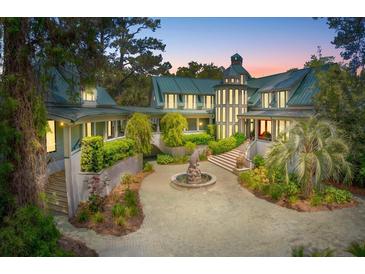 Stately home featuring a circular driveway, elegant fountain, and lush landscaping at 2970 Roseville Rd, Wadmalaw Island, SC 29487