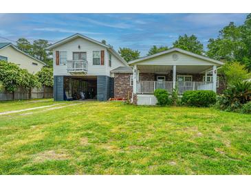 Charming two-story home with a well-maintained lawn and a covered front porch perfect for relaxing at 312 Lake Moultrie Dr, Bonneau, SC 29431