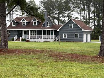 Charming two-story home with a welcoming front porch, lush lawn, and attached two car garage at 341 Sugar Hill Rd, Saint George, SC 29477