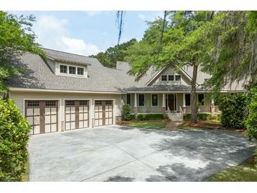 Charming home featuring a three-car garage, and welcoming front porch with manicured landscaping at 3924 Regal Oak Ln, Johns Island, SC 29455