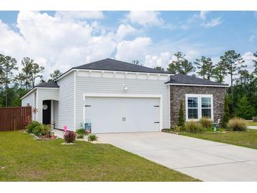 Charming single-story home with light siding, stone accents, well-manicured lawn, and a two-car garage at 477 Spanish Wells Rd, Summerville, SC 29486