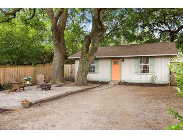 Charming home featuring a cozy gravel area with Adirondack chairs and a fire pit, nestled under mature trees at 5037 Alpha St, North Charleston, SC 29405