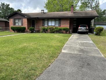 Charming brick home with well-manicured lawn, mature landscaping, and carport at 6305 Brandt St, North Charleston, SC 29406