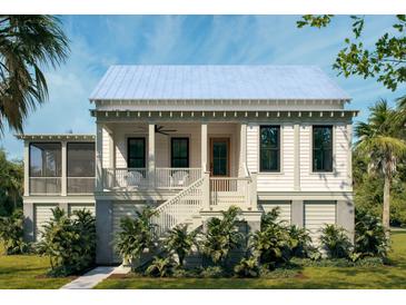 Charming white two-story home with a inviting front porch and beautiful tropical landscaping at 7059 Sounding Ln, Johns Island, SC 29455